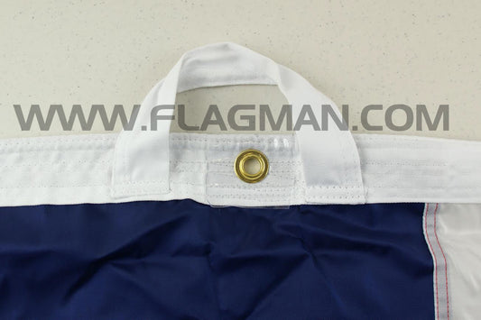 Close-up of a flag with a grommet on a white background, featuring the website 'www.flagman.com'.
