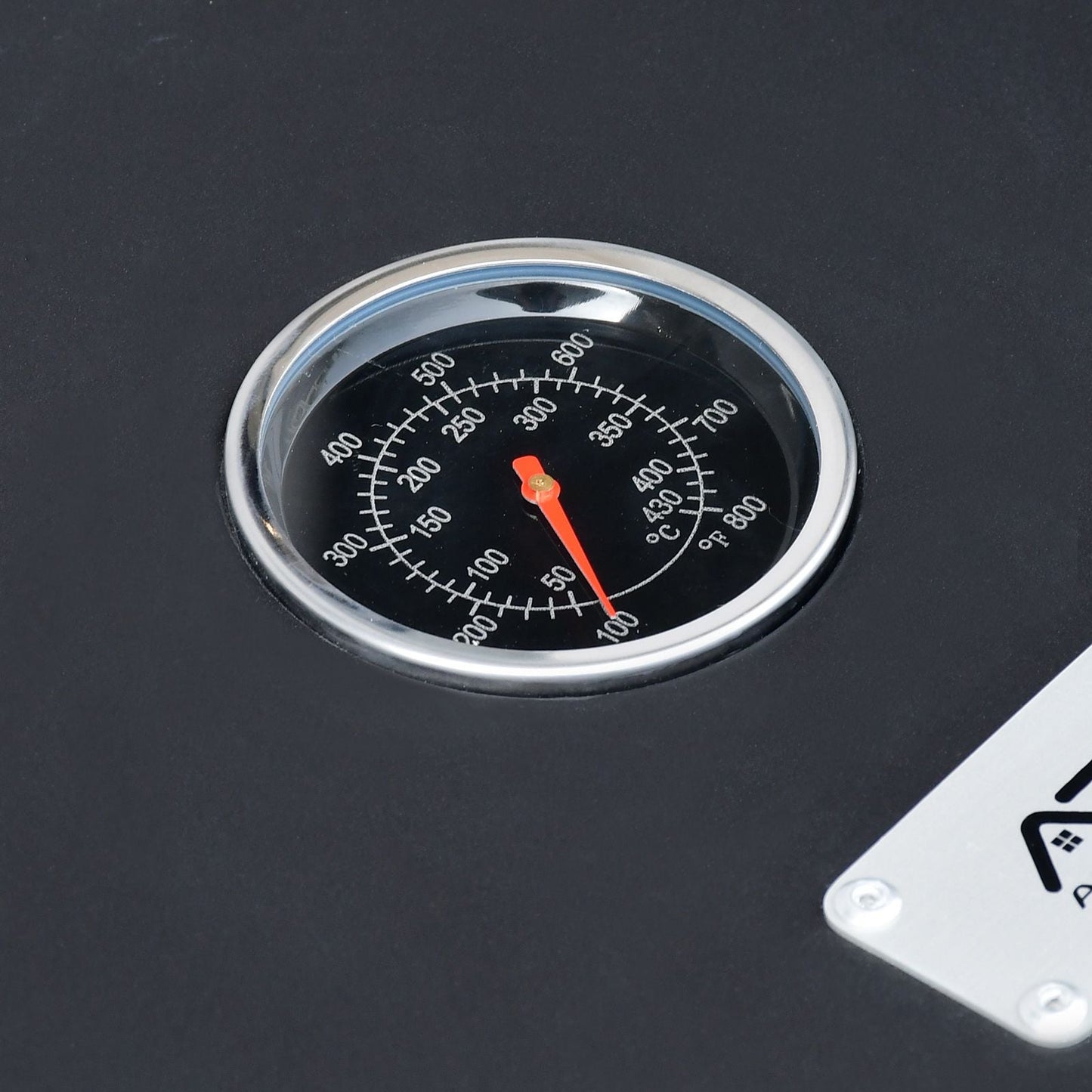Temperature gauge on a black surface with a red needle pointing to a temperature.