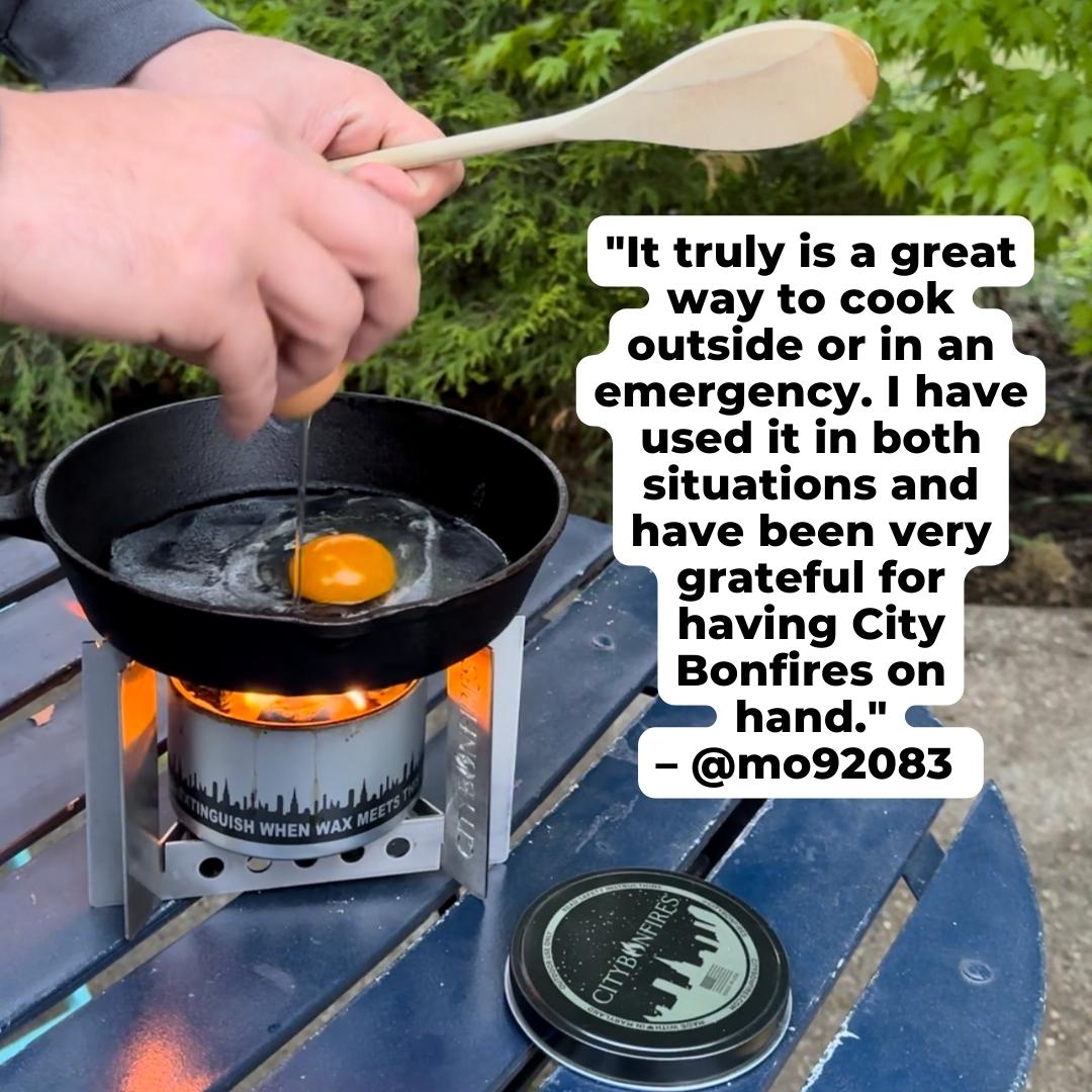 Person cooking an egg on a portable stove with a City Bonfires product in the background.