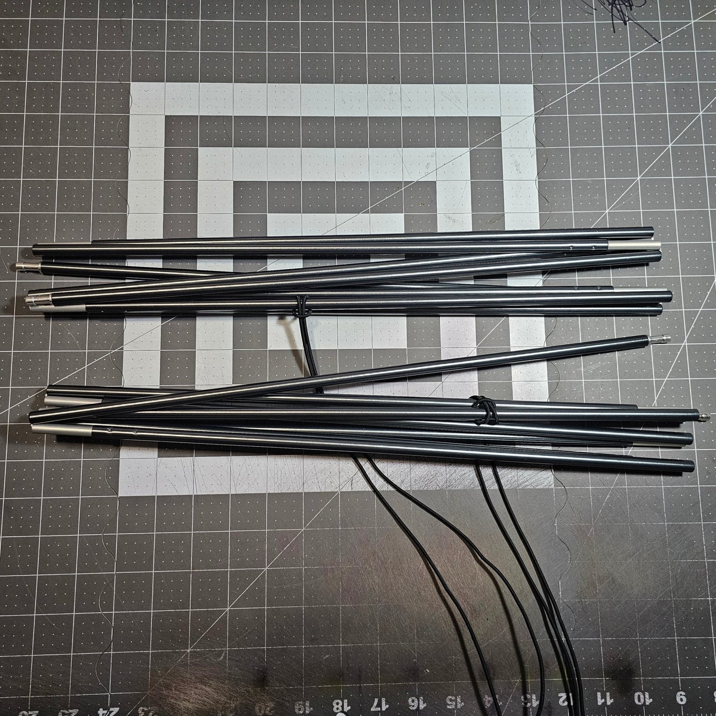 Set of metal rods on a grid-patterned surface