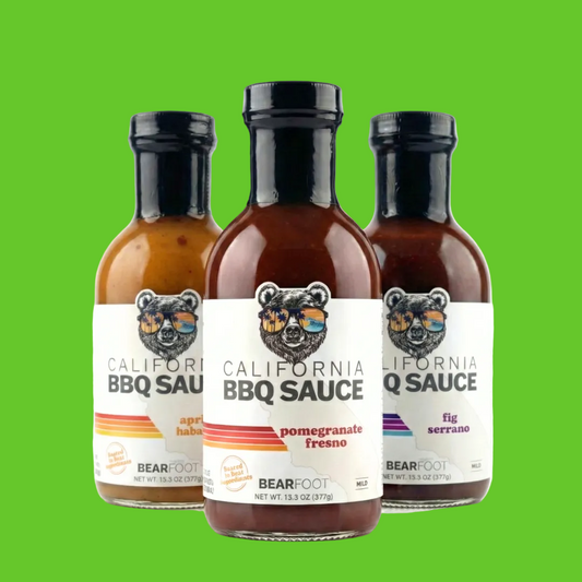 Three bottles of Bearfoot California BBQ Sauce arranged together on a white background, showing apricot habanero, pomegranate fresco, and fig serrano flavors.