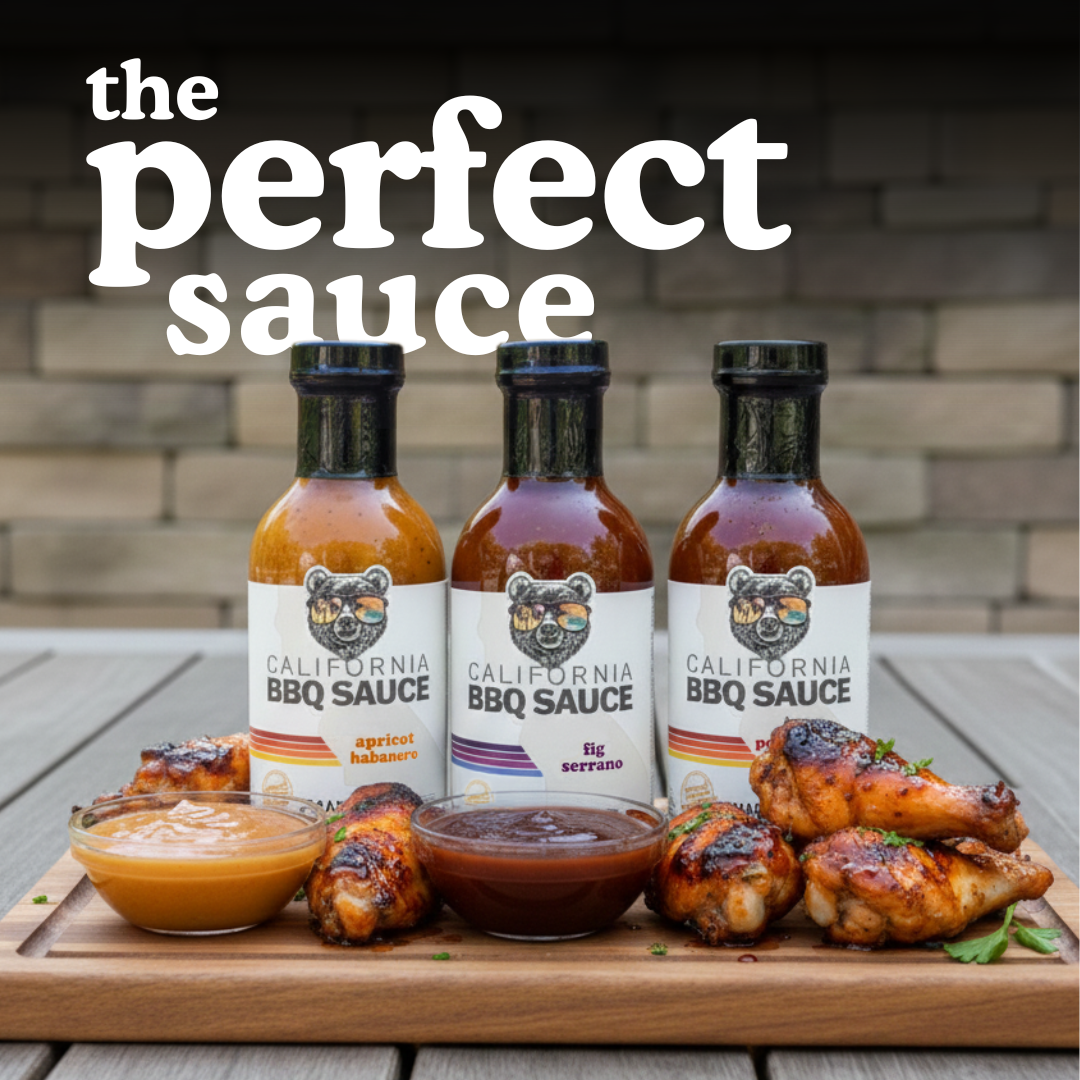Three bottles of California BBQ Sauce with wings and sauce on a wooden board outdoors.