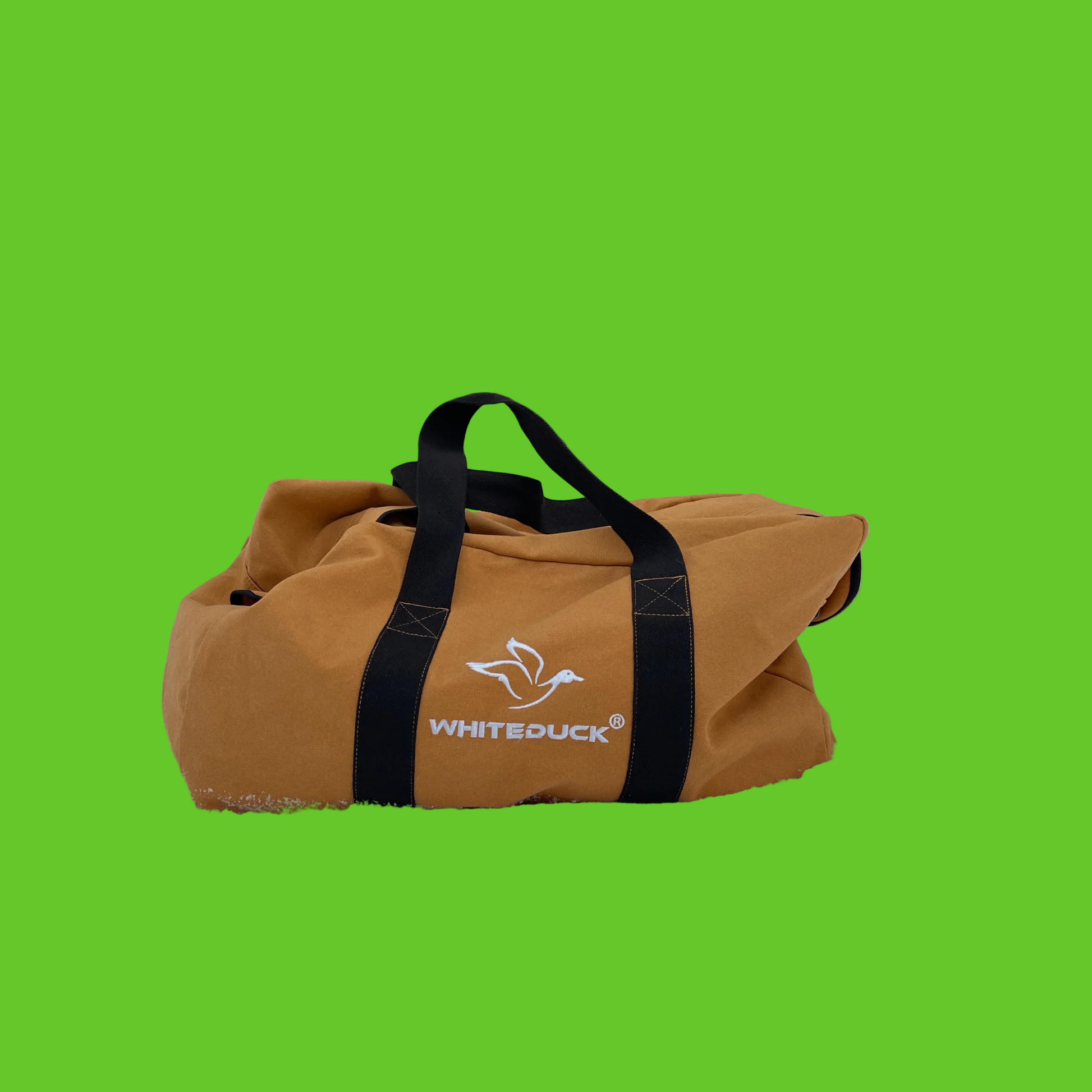 Brown duffel bag with black straps on a snowy ground, featuring the 'Whiteduck' brand.