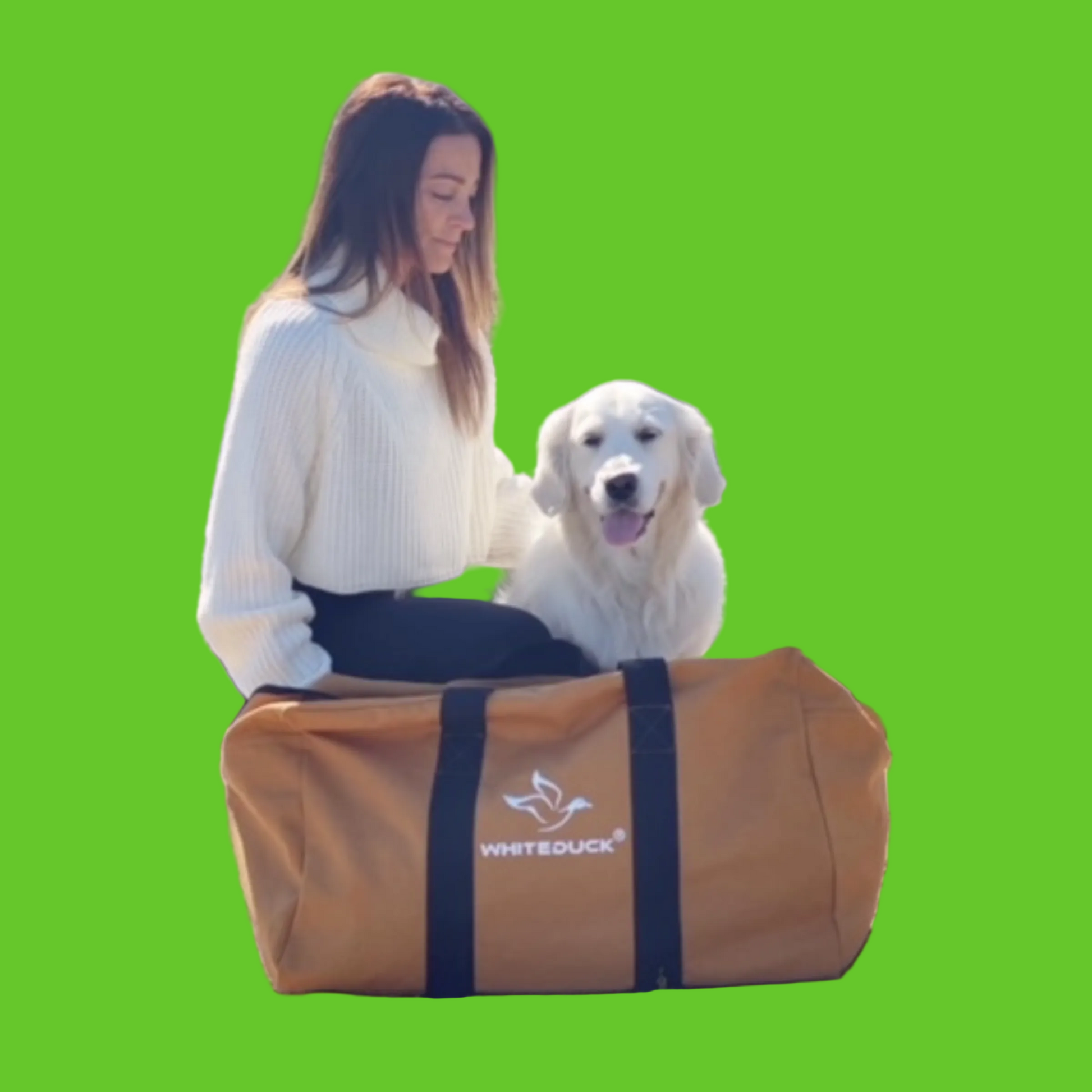 Woman with a white dog sitting next to a large brown duffel bag in a desert setting.