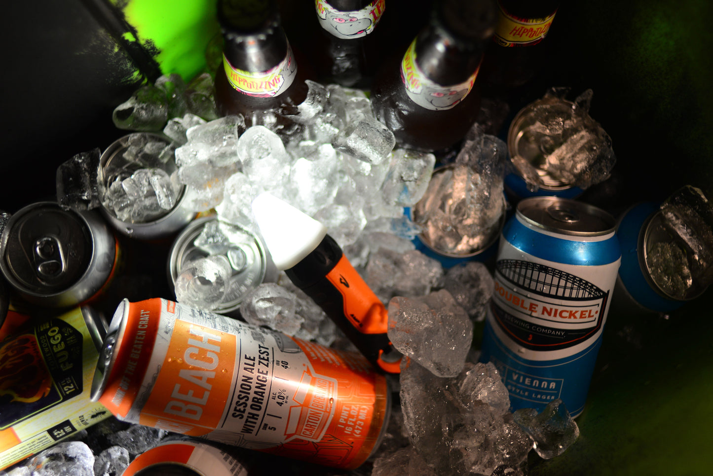 Assorted beer cans on ice with a focus on 'Beach Ale' and 'Double Nickel'.