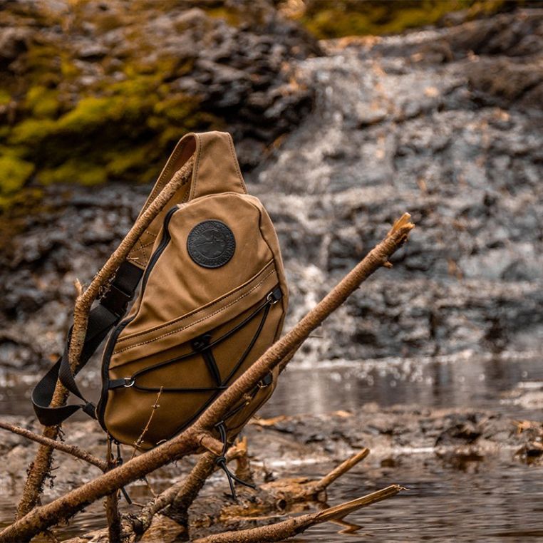 Brown sling bag on a branch with a natural background