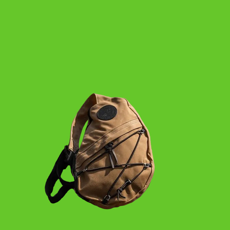 Tan backpack with black straps on a rocky surface