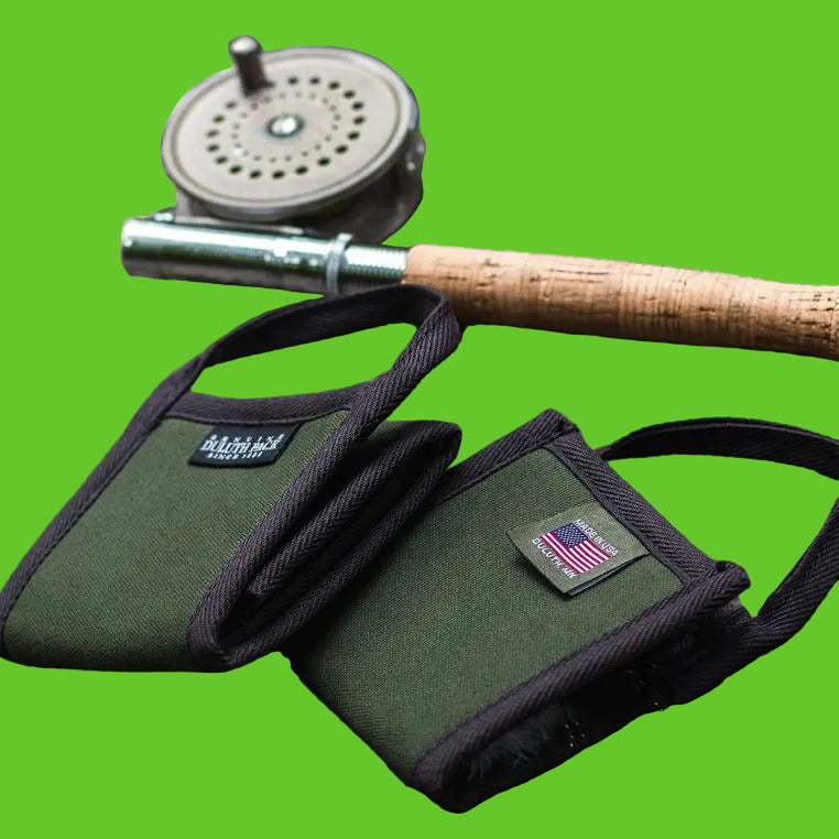 Two green fishing reel cases with a fishing rod and reel on a stone surface.