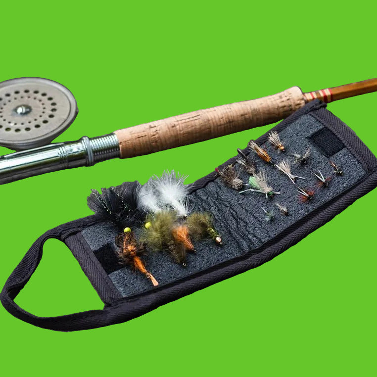 Fishing rod and reel with fly fishing flies on a stone surface