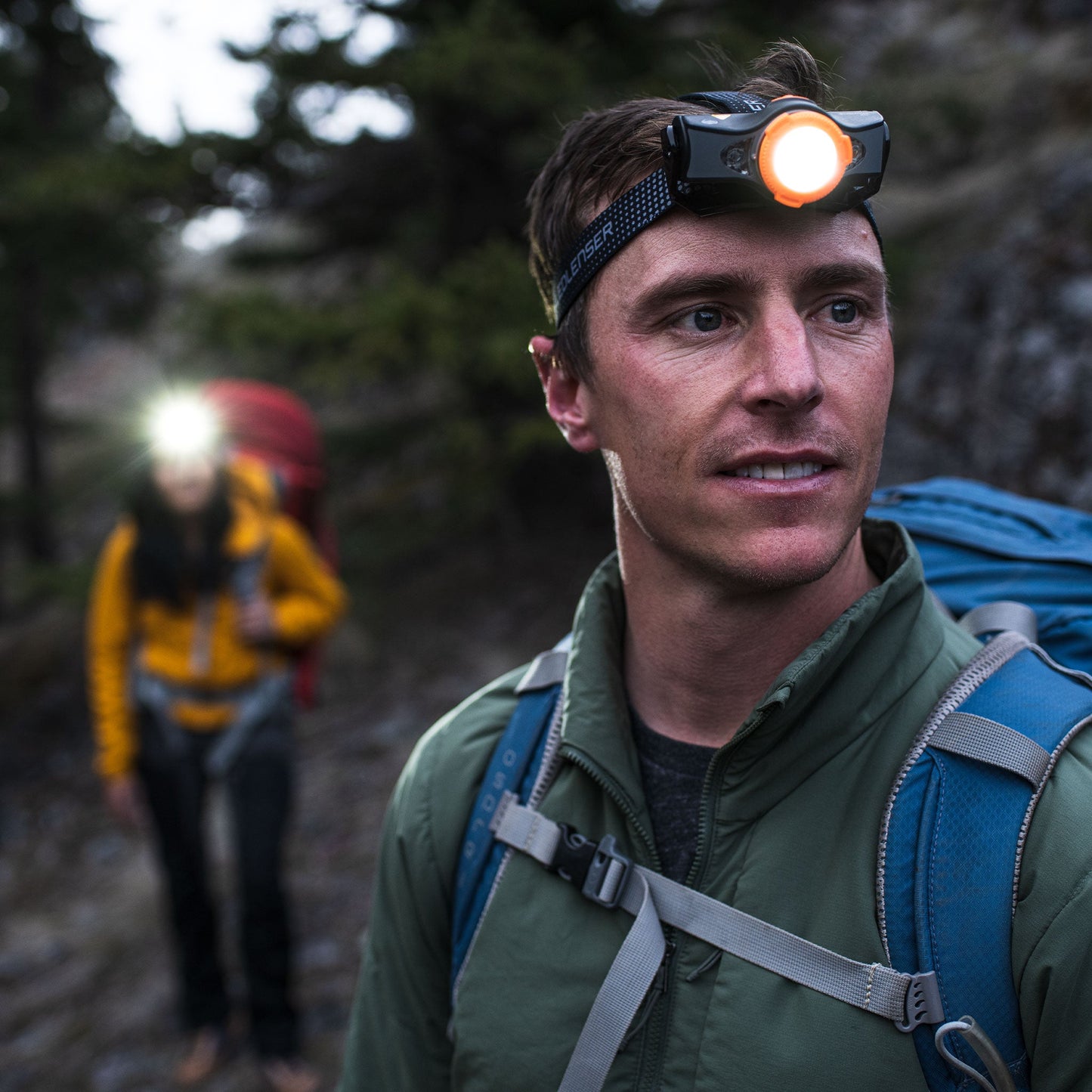 Man hiking with a headlamp in a forest setting