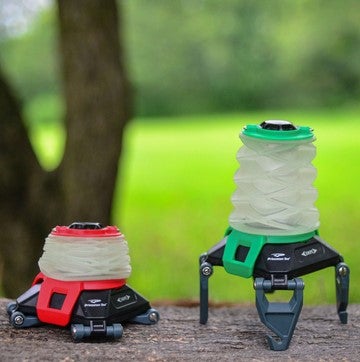 Two collapsible water bottles on stands with a blurred natural background