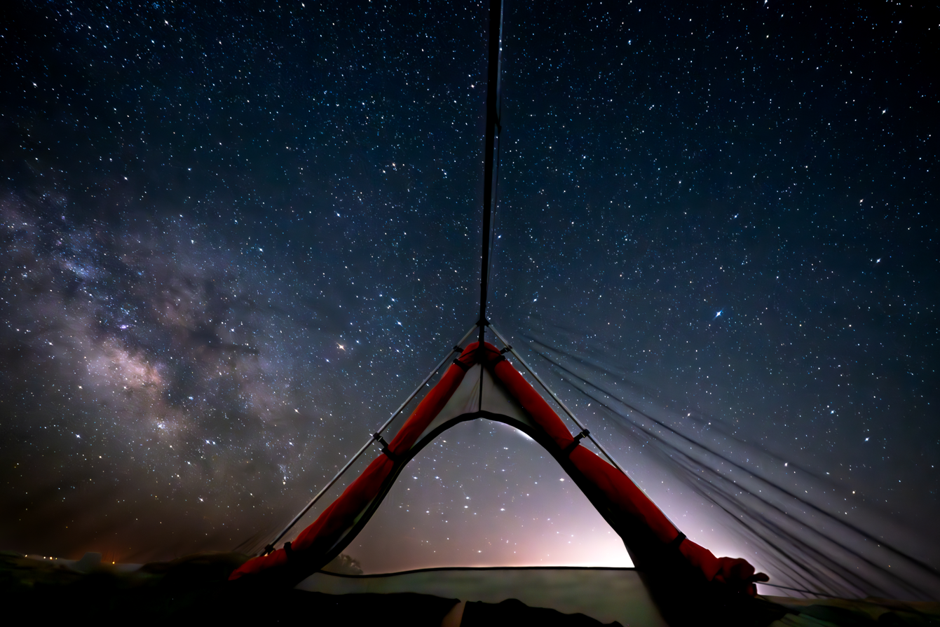 Red tent under a starry night sky with the Milky Way galaxy.