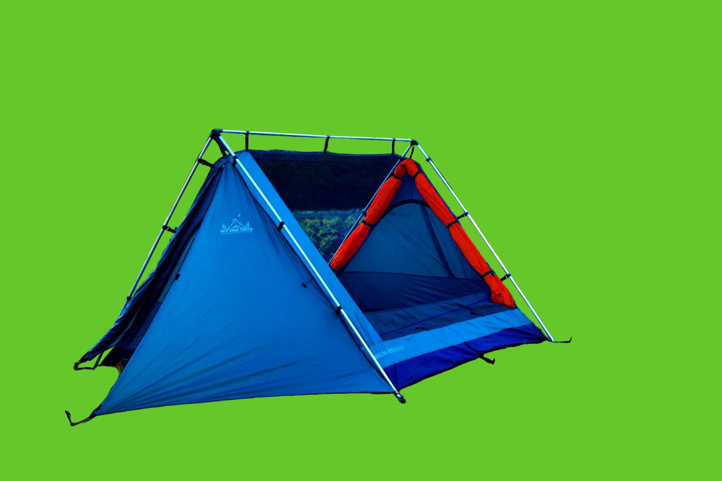Camping tent with red interior in a field with mountains in the background