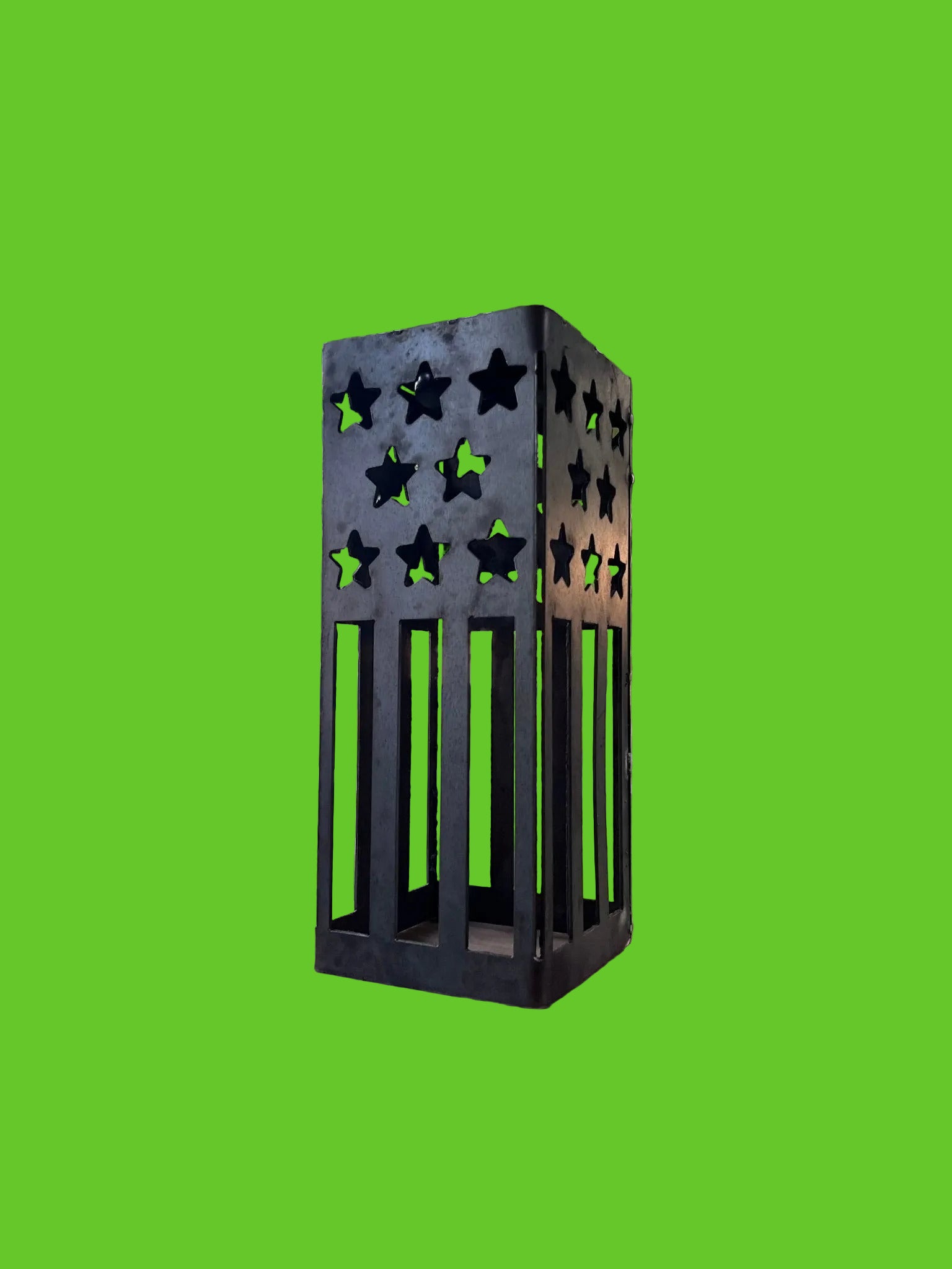 Black metal star-patterned lantern on a wooden surface with a scenic background