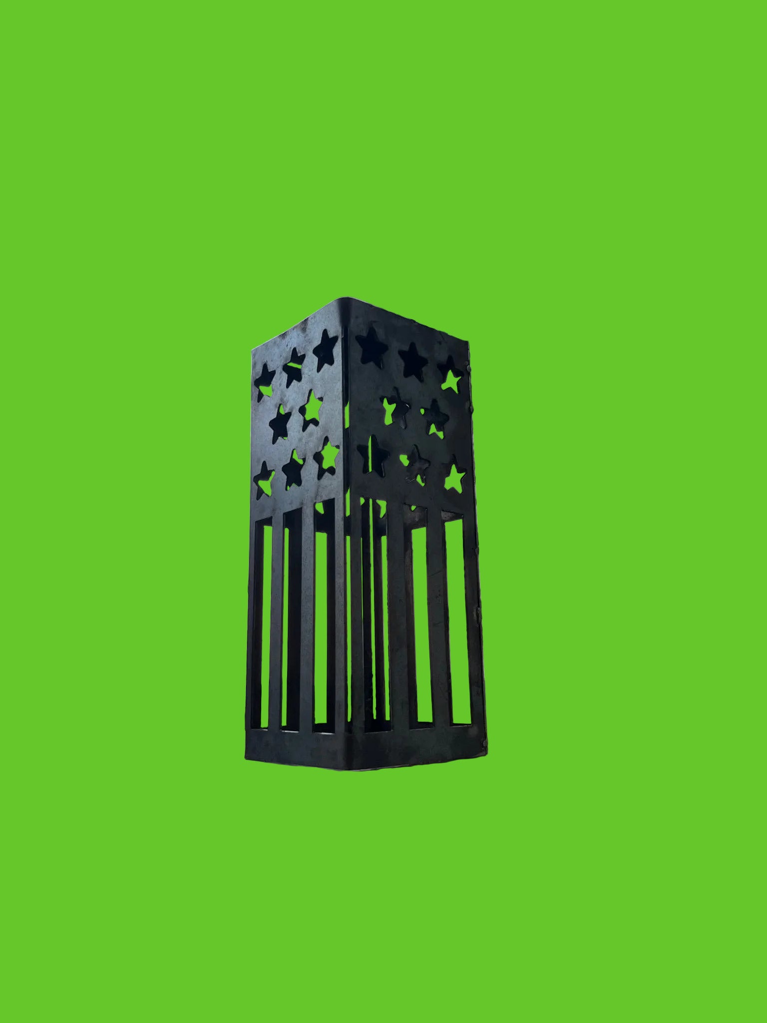 Black metal lantern with star patterns on a wooden surface outdoors