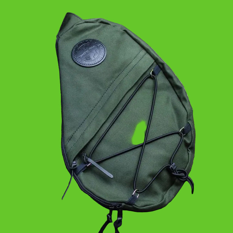 Green sling bag with a brand logo on rocks