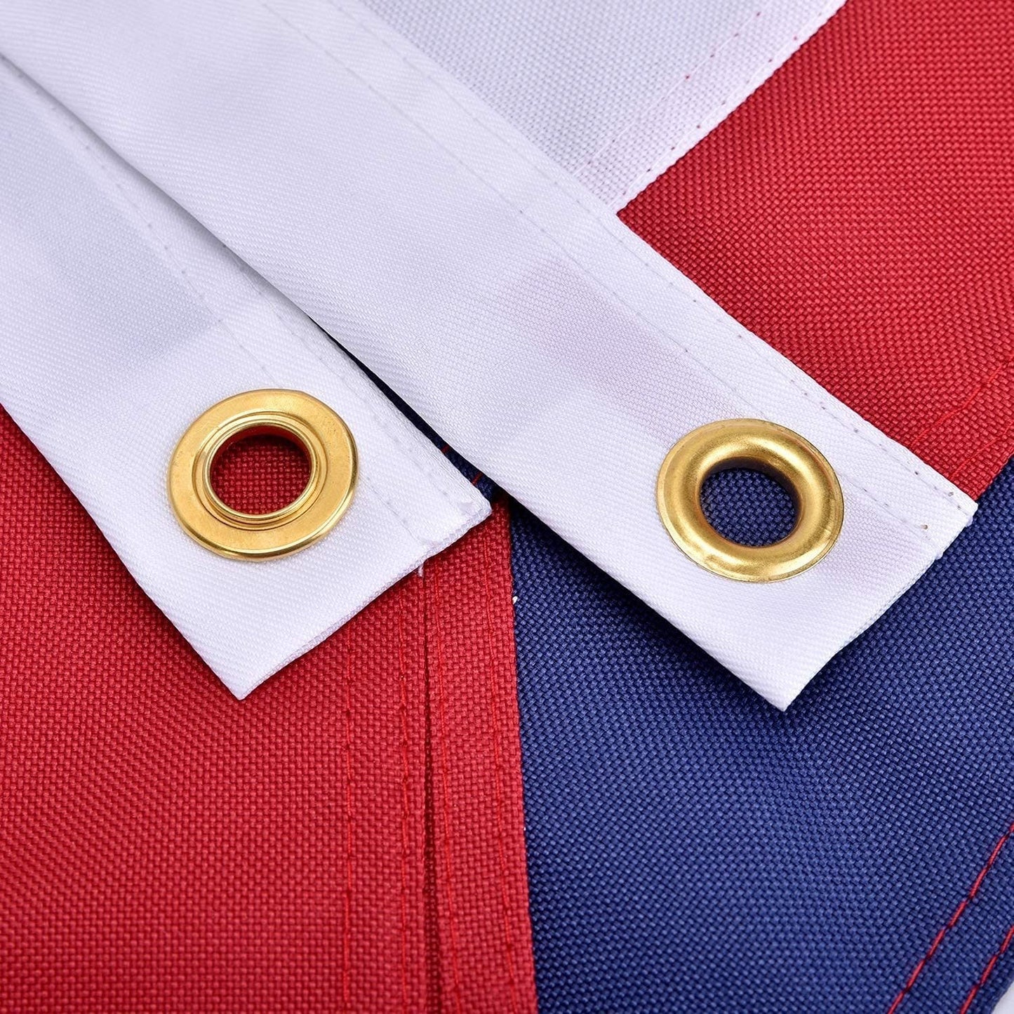 Close-up of a flag with gold eyelets on a red, white, and blue background