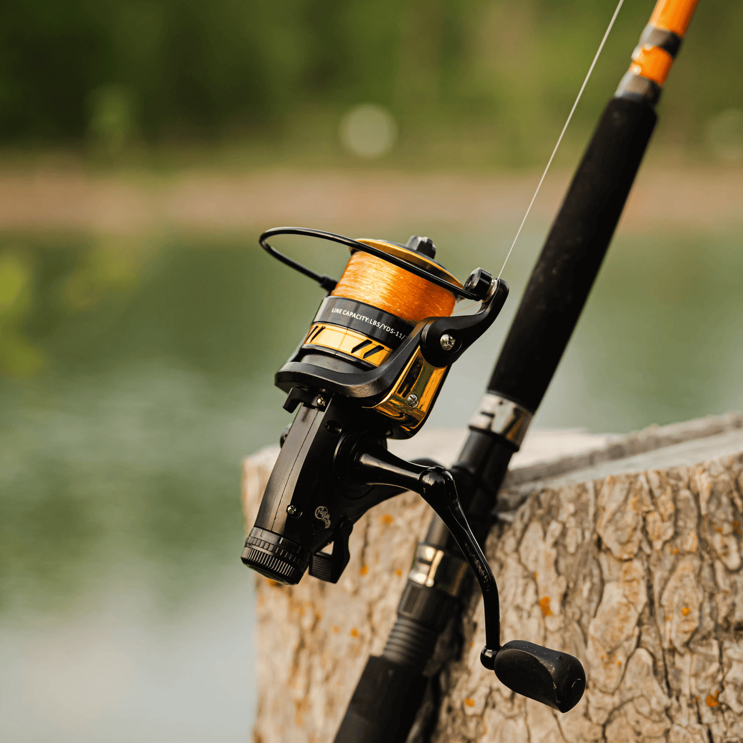 Fishing rod with reel on a wooden post by a body of water