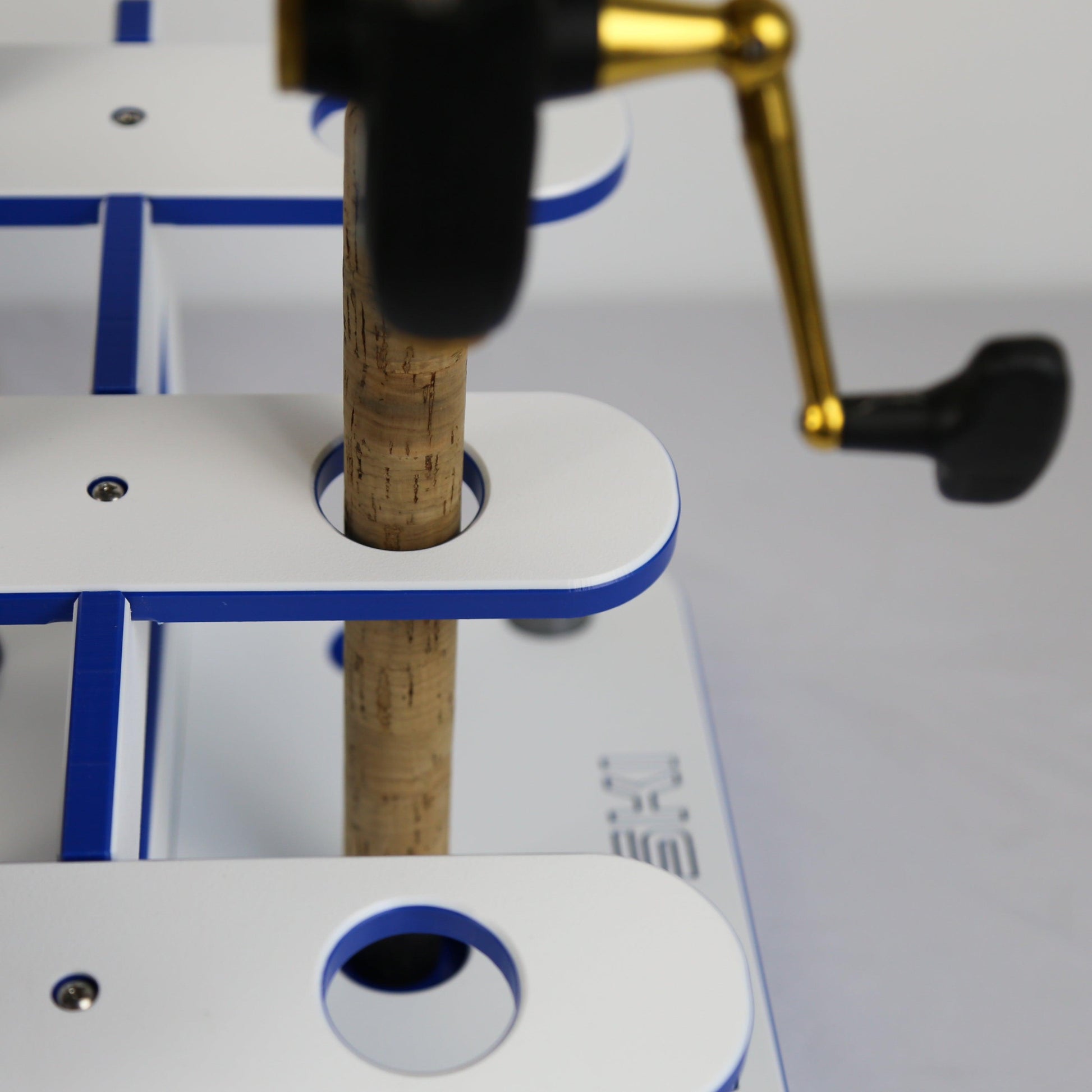 Close-up of a cork being inserted into a wooden block with a tool in the background.