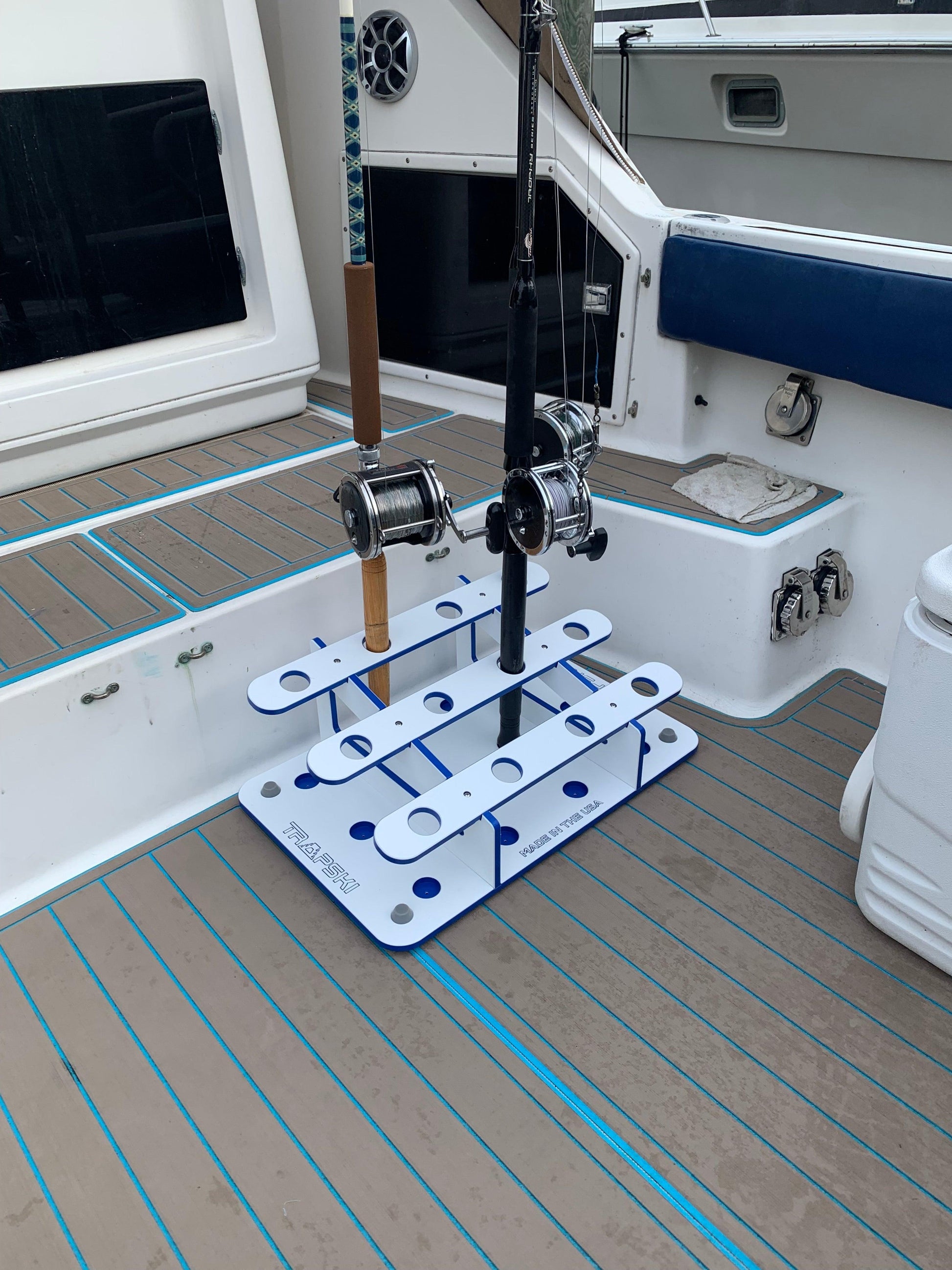 Fishing rod holder on a boat deck with fishing rod and reel.