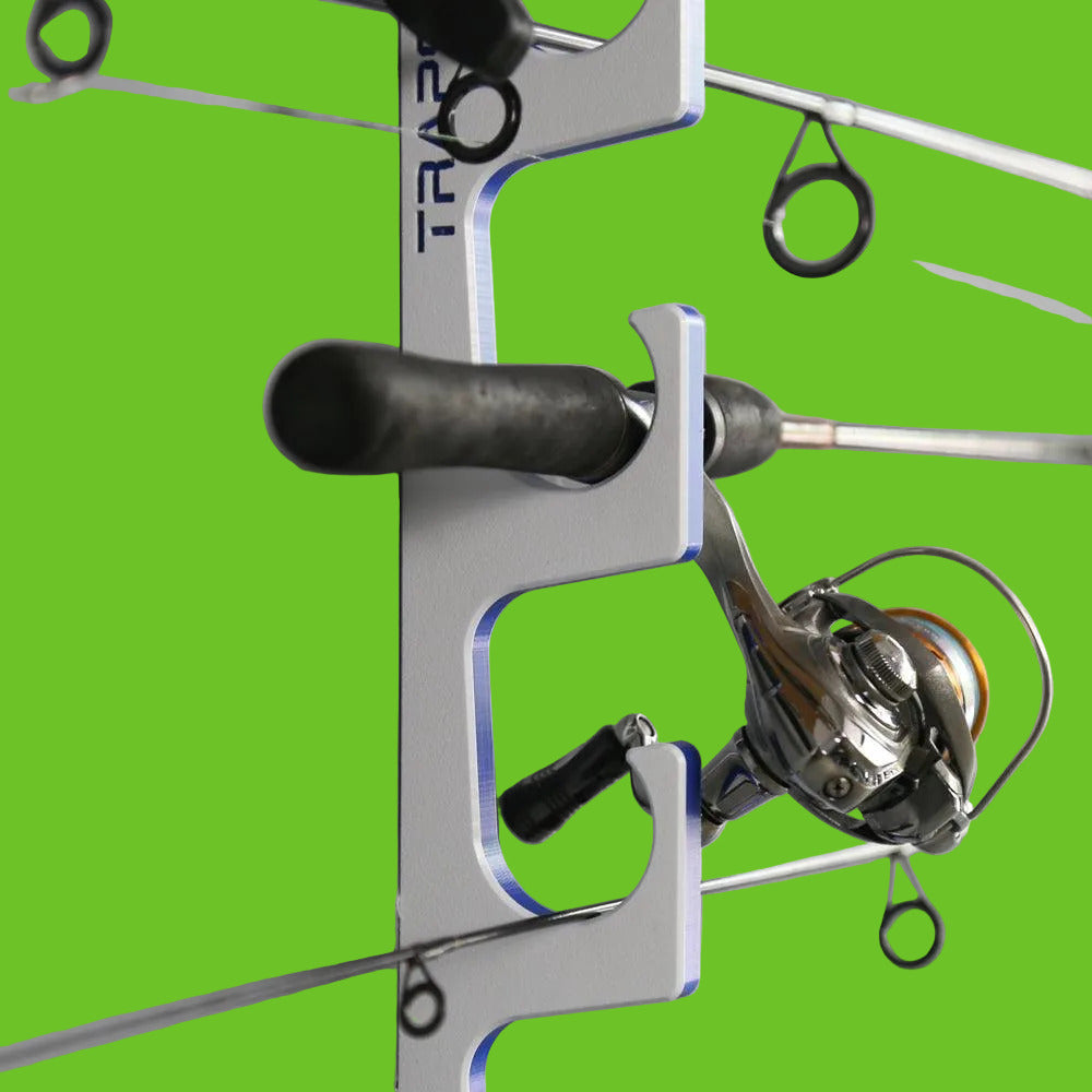 Fishing reel mounted on a wall-mounted holder with 'TRAPT' branding.
