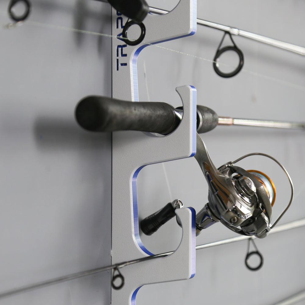Fishing reel mounted on a wall-mounted holder with 'TRAPT' branding.