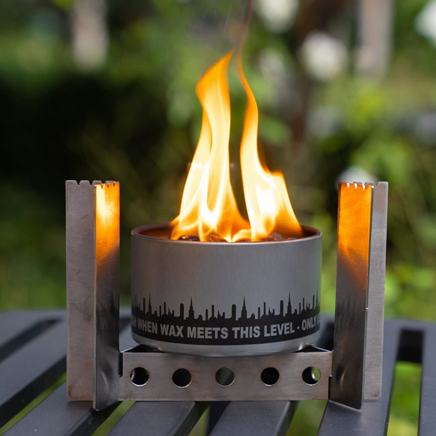 Portable fire pit with flames on a blurred natural background